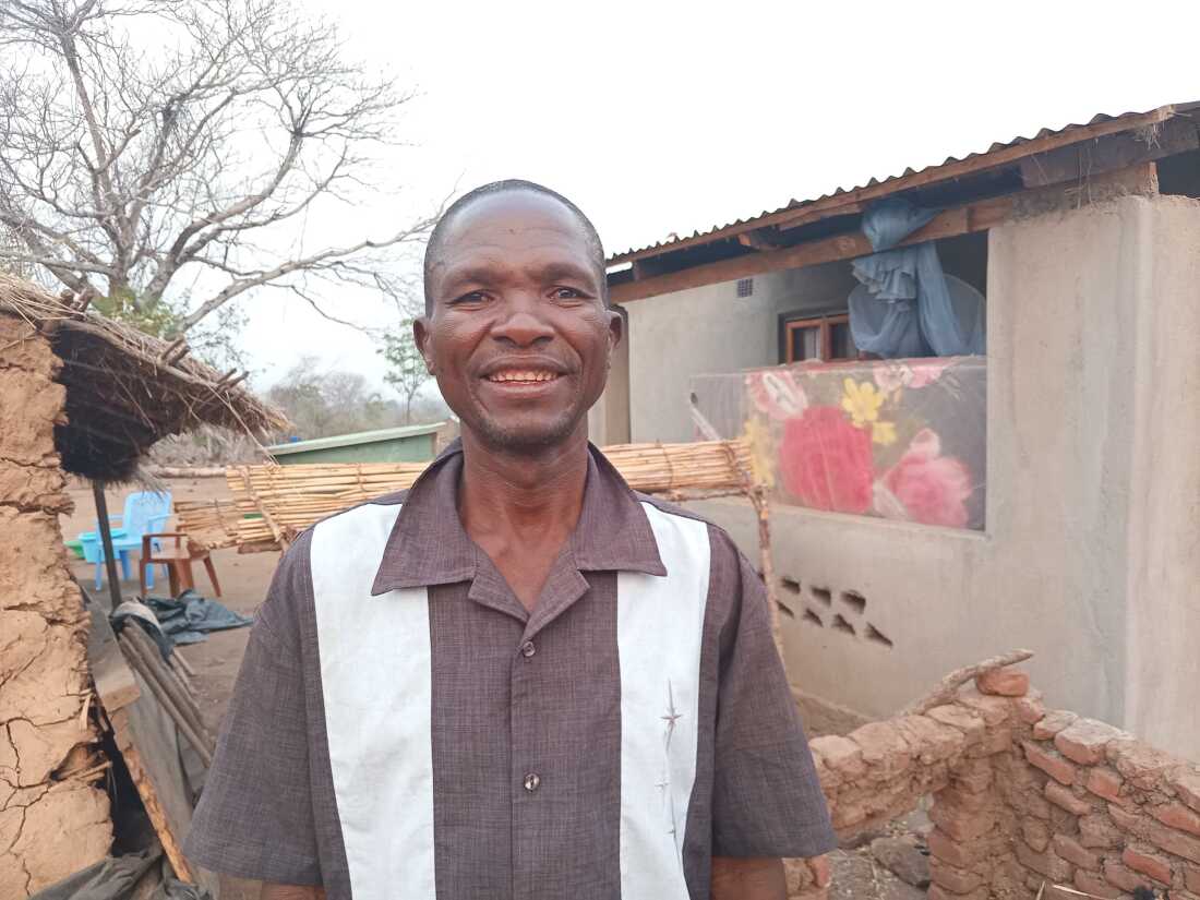 Christopher Bingala, a farmer in Malawi, stands outside his new home. After losing his house in Cyclone Freddy, he received a payment from a new fund for the damages from climate-related disasters.