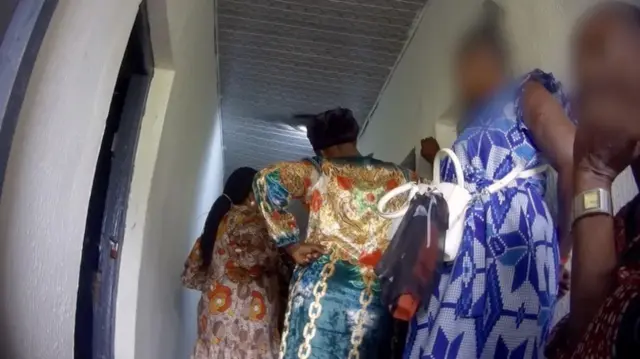 نساء يرتدين فساتين زاهية مزخرفة وهن يقفن في الممر في انتظار المقابلة 