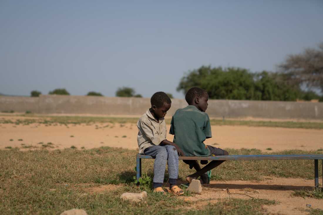 Mahawat Zakaria Jouma's younger brothers, Hassan and Hussein, sit together on a bench at the soccer field where their brother likes to play.