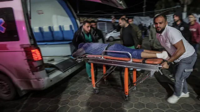 رجل فلسطيني مصاب يُنقل على نقالة إلى مستشفى الأقصى في دير البلح بعد غارة جوية إسرائيلية على مخيم النصيرات للاجئين، وسط قطاع غزة.