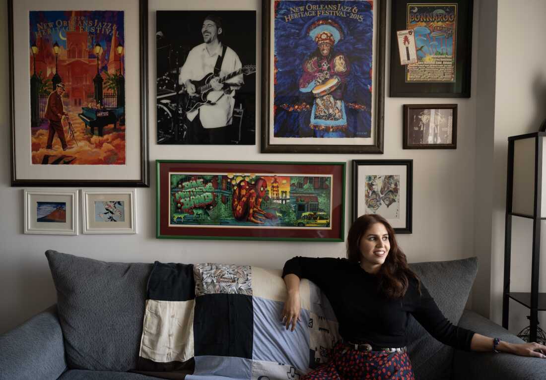 Amanda Kastrinos at her apartment in New York City, decorated with concert and festival posters, as well as a black and white photo of her dad. "It was impossible not to fall in love with live music growing up with my dad, and listening to music and going to shows is how I stay connected to him," she says. When her father got sick, she learned that there are few resources for young adult caregivers. After his death, she decided to create new tools to help.
