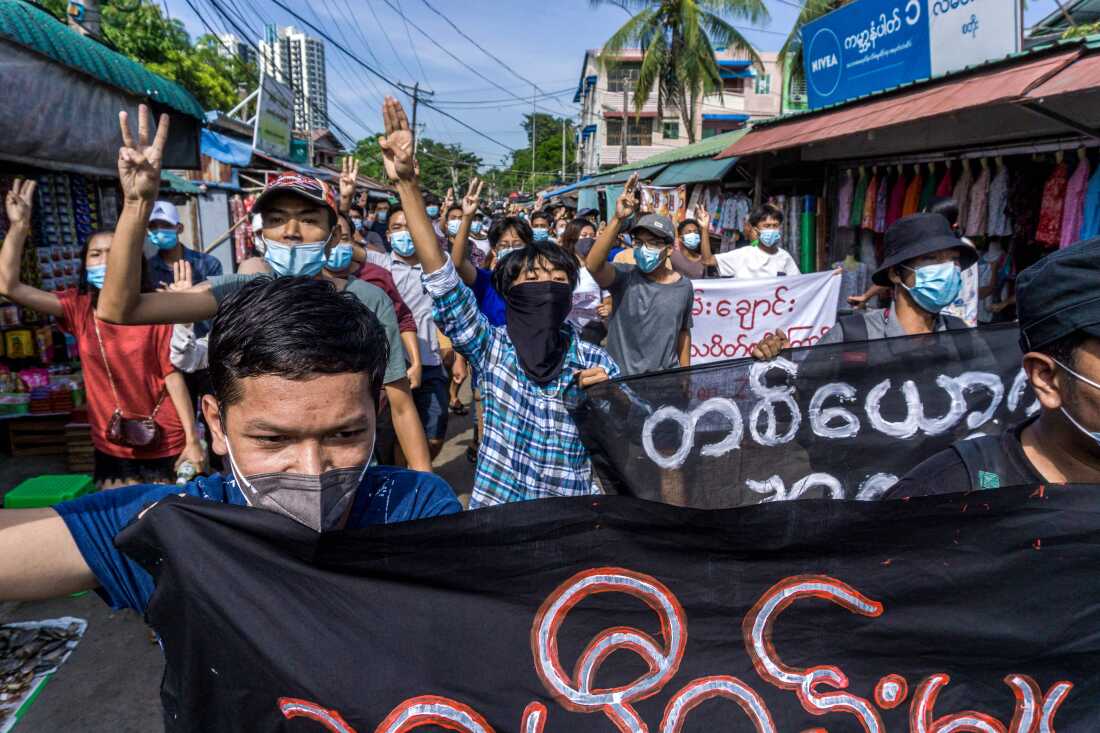 Protesters make the three-finger salute during a demonstration against the military coup in Yangon on May 15, 2021.