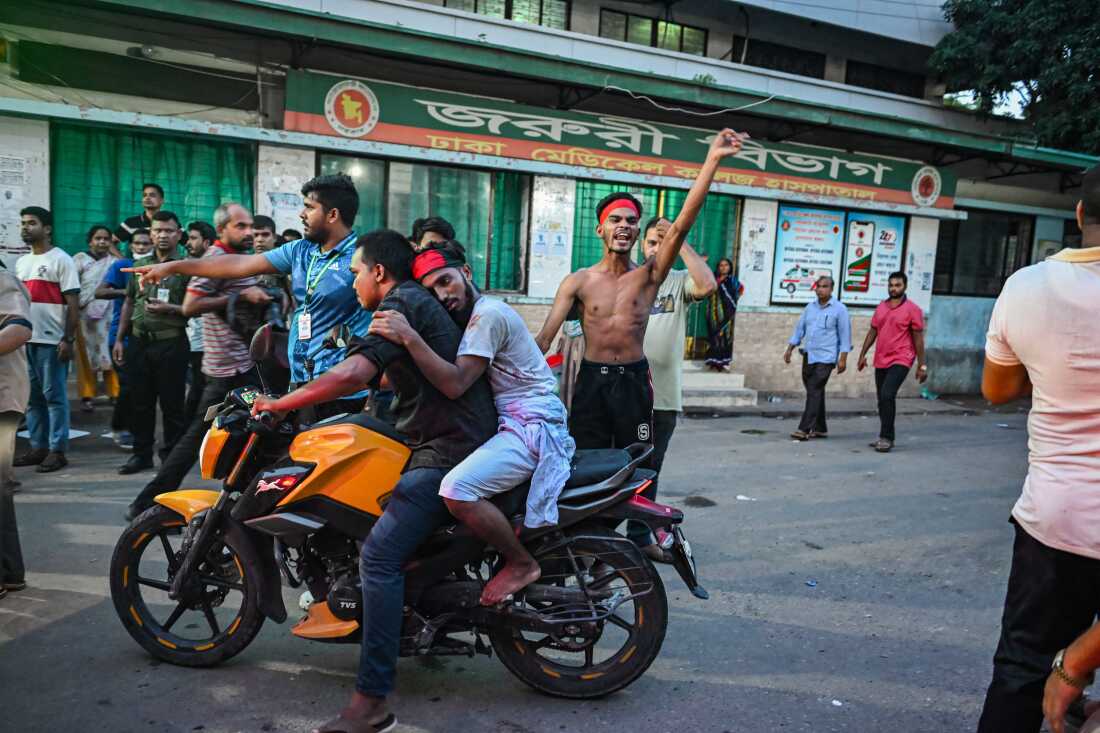 An injured protester is brought on the back of a motorbike for treatment at Dhaka Medical College Hospital on August 4.