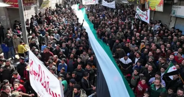 متظاهرون في إدلب يطالبون بالإفراج عن المعتقلين وإنهاء حكم هيئة تحرير الشام. مارس/آذار 2024 