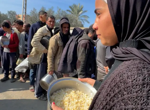فتاة تقف للحصول على الأرز