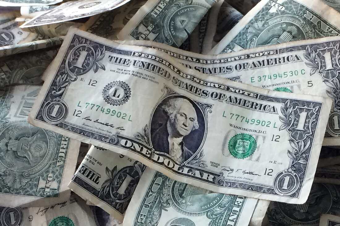 Dollar bills are shown in New York. The Economic Policy Institute says the January 1 minimum wage increases show that the "minimum wage continues to be a powerful tool for combating racial and gender wage disparities."