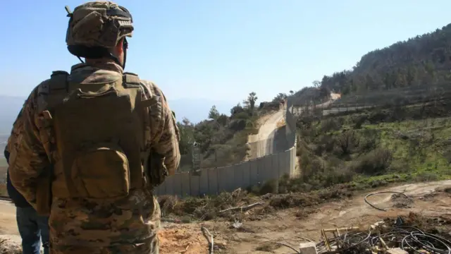 جندي لبناني يطل على الجدار الحدودي مع إسرائيل 