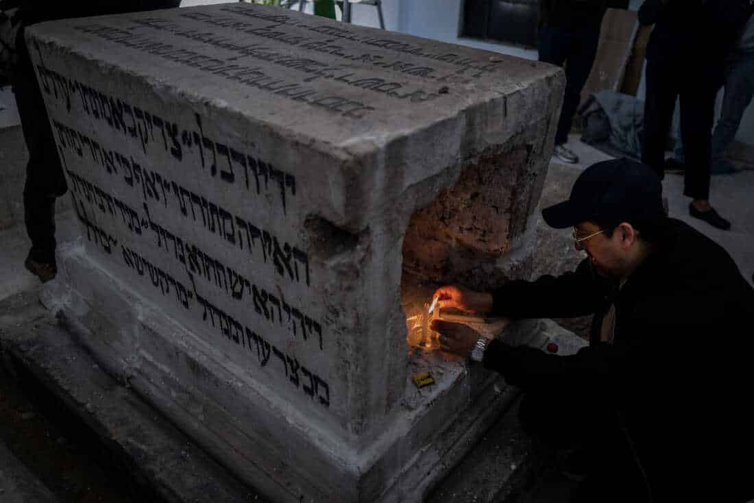DAMASCUS, Syria, 02/17/25 Cantor Harry Hamra lights a candle at the 400-year-old grave of Rabbi Hayam Vital a key figure in Kaballah mystical Judaism. Ayman Oghanna for NPR