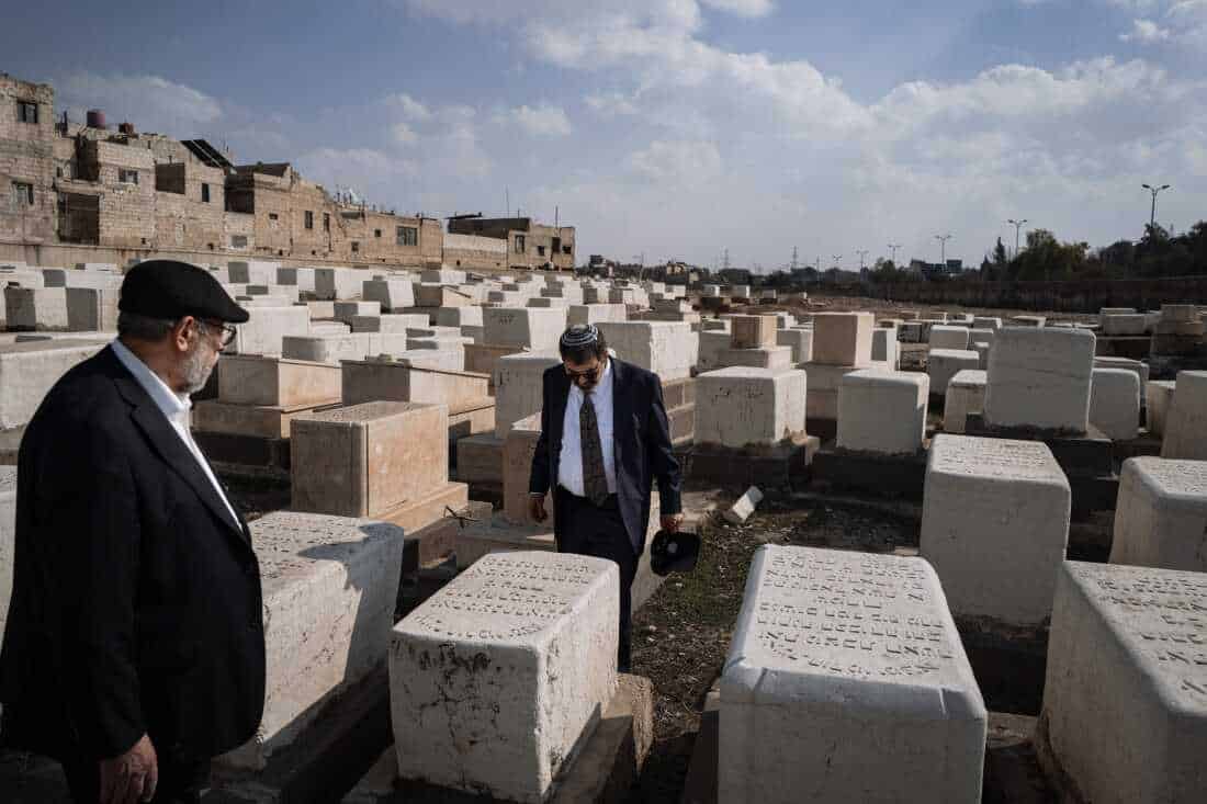 Rabbi Asher Lopatin and Rabbi Yousif Hamra walk among the tombstones engraved with Hebrew in the historic Jewish cemetery of Damascus.