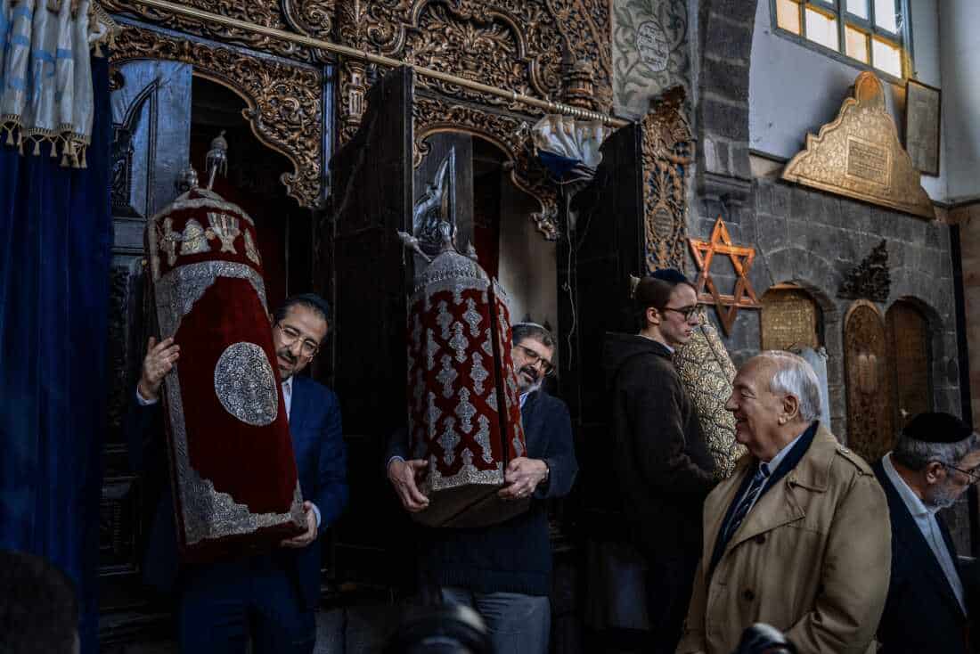 DAMASCUS, Syria, 02/18/25 Members of the Jewish delegation carry an historic Torah in the 500-year-old Faranj synagogue in Damascus. Ayman Oghanna for NPR