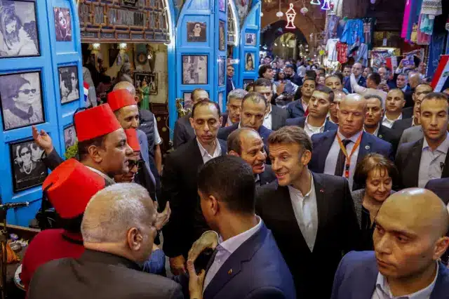 الرئيس الفرنسي إيمانويل ماكرون ونظيره المصري عبد الفتاح السيسي يتحدثان إلى الموظفين في مقهى أم كلثوم في خان الخليلي بحي الجمالية في 6 أبريل/نيسان 2025.