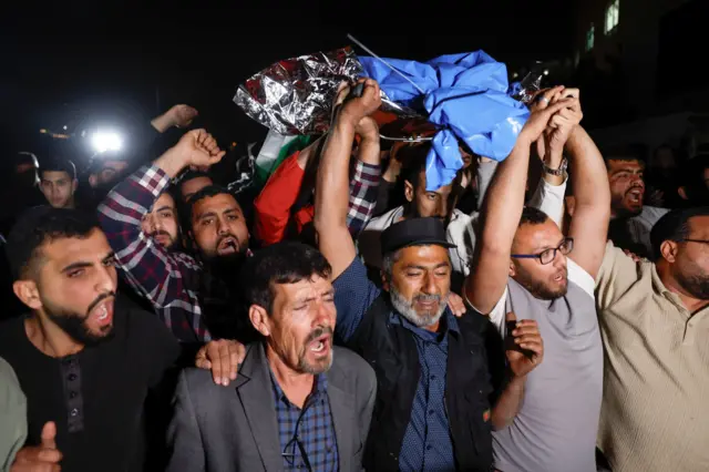 فلسطينيون يحملون جثمان الطفل الفلسطيني الأمريكي عمر ربيع، 14 عاماً، الذي قتلته القوات الإسرائيلية في قرية ترمسعيا قرب رام الله في الضفة الغربية المحتلة