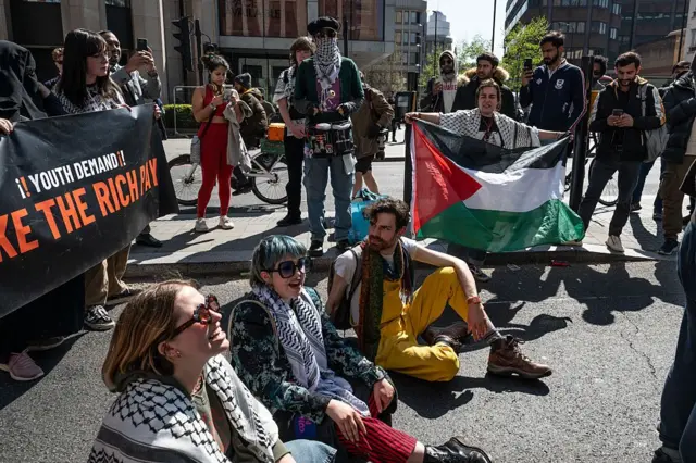 متظاهرون في لندن يحملون العلم الفلسطيني ويرتدون الكوفيات الفلسطينية يطالبون الحكومة البريطانية بوقف تصدير الأسلحة لإسرائيل- أبريل/ نيسان 2025.