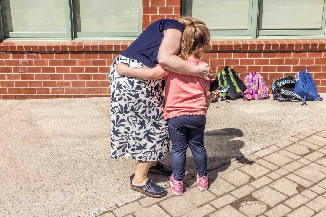 Barbara Welch hugs a student goodbye at the end of the day. 