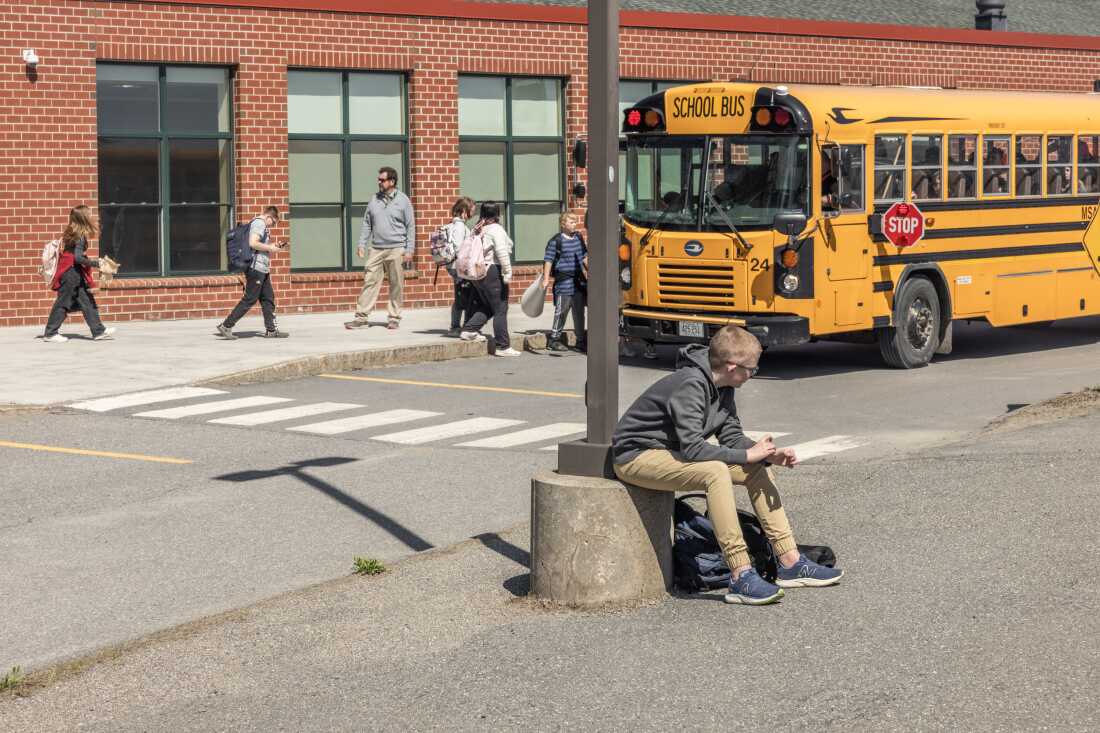 Students wait for buses in front of Mill Stream Elementary School.