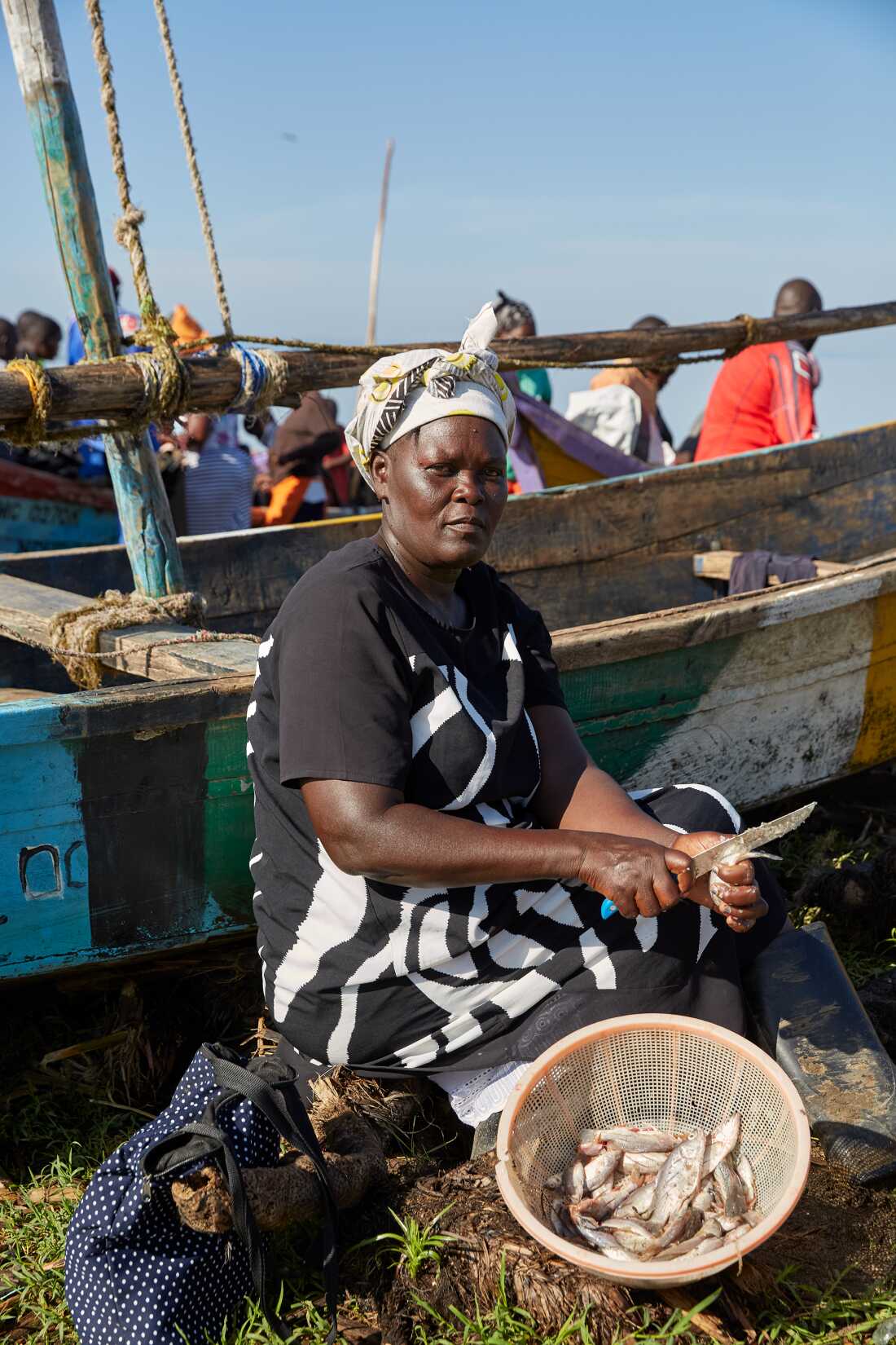 Rebbeccah Atieno, a No Sex For Fish member, scales and guts the fish she bought from fellow member Alice Akinyi at Nduru beach, Kisumu, Kenya, 2025.