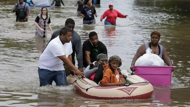 عائلات تستخدم القوارب المطاطية في محاولة للنجاة من مياه الفيضانات في تكساس.