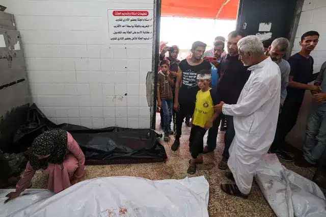فلسطينيون يودعون أقاربهم في مشرحة مستشفى شهداء الأقصى بدير البلح وسط قطاع غزة، في الأول من يوليو/تموز 2025، بعد غارات إسرائيلية ليلية. 