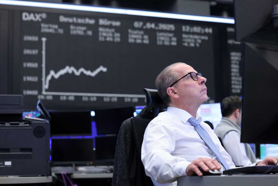 A trader works in front of a board displaying the chart of Germany's DAX index at the stock exchange in Frankfurt, Germany, on April 7, 2025. German stocks have surged this year, outpacing gains in the U.S.