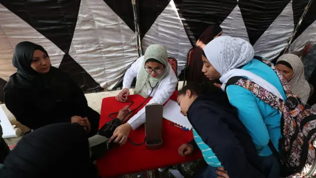 دكتورة تقوم بالكشف الطبي على مجموعة من النساء