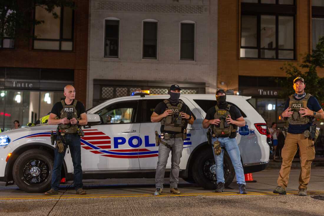 Police officers set up a roadside checkpoint at night.