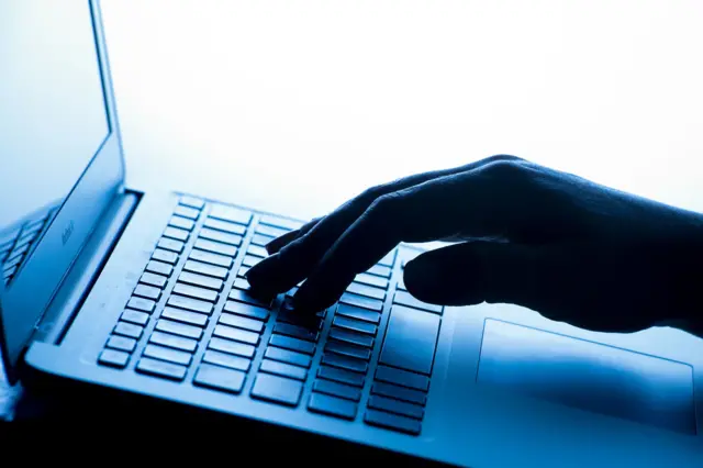 مقرّبة للوحة مفاتيح حاسوب محمول، تظهر فيها يد امرأة تضغط على مفتاح في لوحة مفاتيح حاسوب محمول: