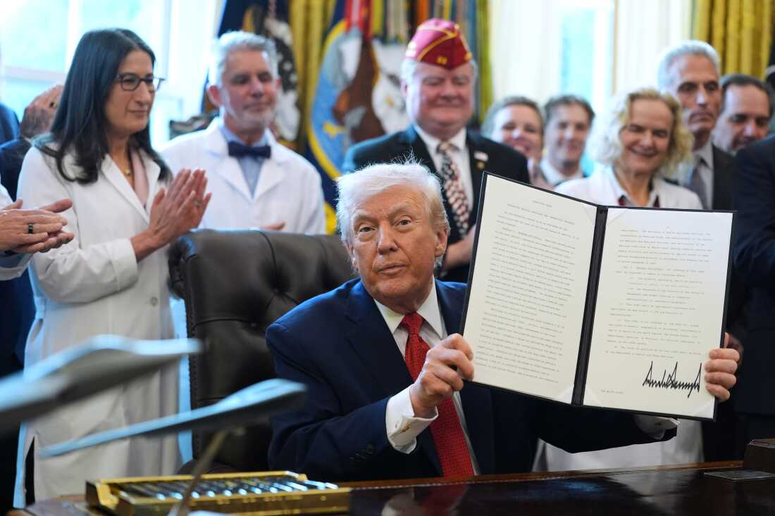 President Trump displays an executive order reclassifying marijuana as a less dangerous drug in the Oval Office on Dec. 18.