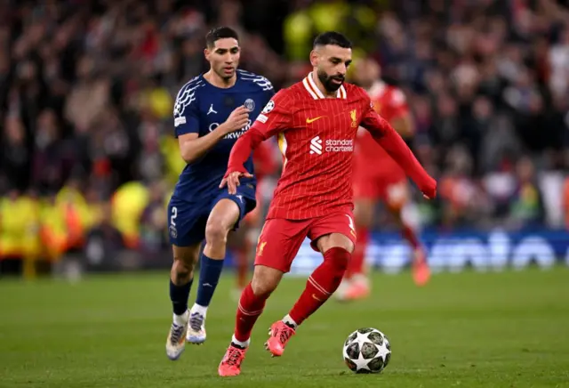 محمد صلاح، لاعب ليفربول، يركض بالكرة تحت ضغط من أشرف حكيمي، لاعب باريس سان جيرمان، خلال مباراة الإياب من دور الـ16 لدوري أبطال أوروبا 2024-2025 بين ليفربول وباريس سان جيرمان على ملعب أنفيلد في 11 مارس/آذار 2025 في ليفربول انجلترا