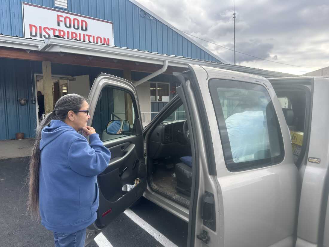 Mary Lefthand watches as workers at the commodity warehouse load food into her truck in St. Ignatius, Montana.