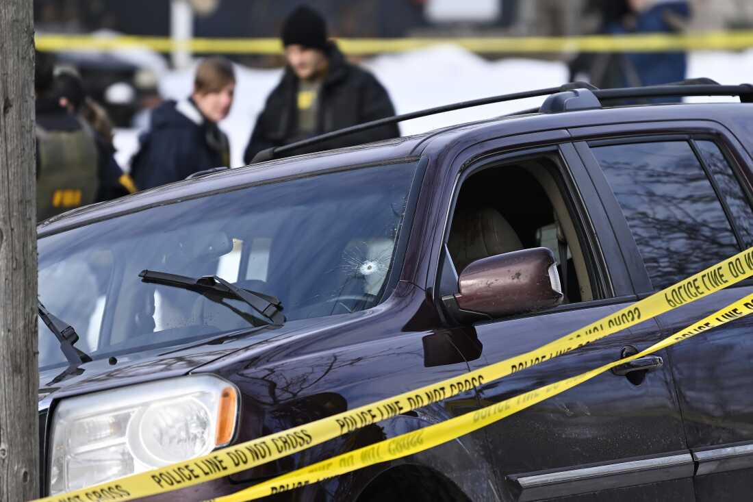 Police tape surrounds Renee Good's car after she was shot and killed by an ICE agent during federal law enforcement operations in Minneapolis on Jan. 7. A bullet hole on the driver's side of the windshield is visible. 