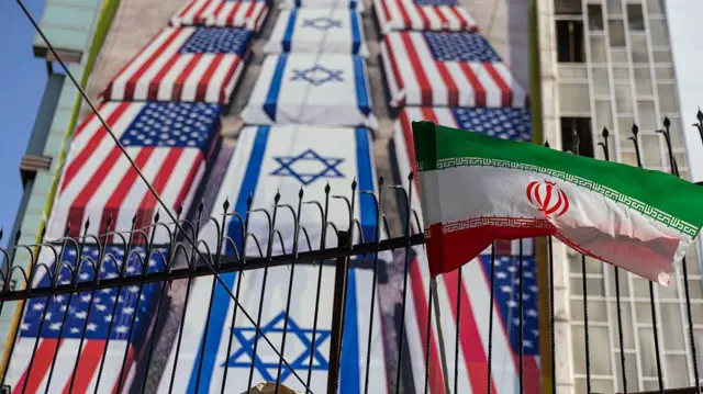 جدارية دعائية في زاوية ساحة فلسطين بوسط مدينة طهران تحذر الولايات المتحدة وإسرائيل من جنودهما.