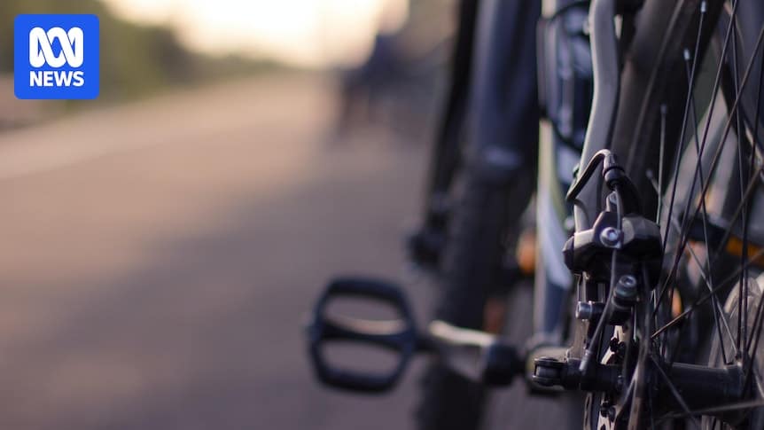 Cyclist riding on a frosty Canberra bike path wearing a puffer jacket, gloves and a balaclava