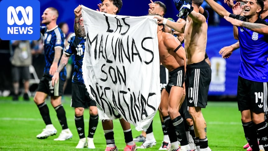 Argentina players holding a banner reading 'Las Malvinas son Argentinas' after World Cup semi-final win over England
