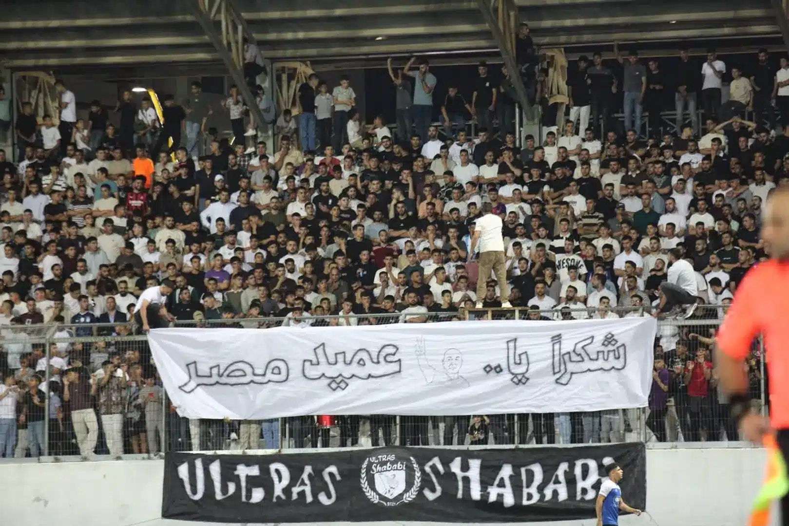 Shabab Al-Khaleel supporters holding a large banner thanking Egypt coach Hossam Hassan inside the stadium